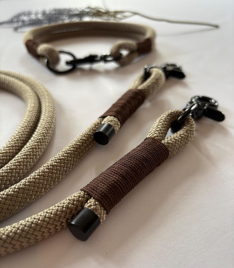 May include: Tan and brown dog collar and leash set. The collar and leash are made of a thick, woven rope material. The leash has a brown wrapped handle and black metal hardware. The collar has a matching brown accent.