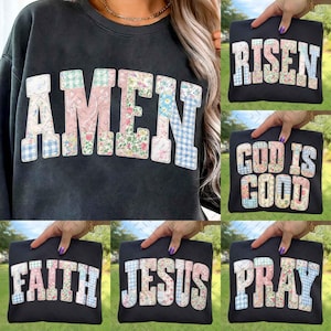 May include: Black sweatshirt with the word "AMEN" in large, patchwork letters. The letters are made of various floral and gingham patterns. Additional images show black tote bags with the words "RISEN", "GOD IS GOOD", "FAITH", "JESUS", and "PRAY" in similar patchwork lettering.