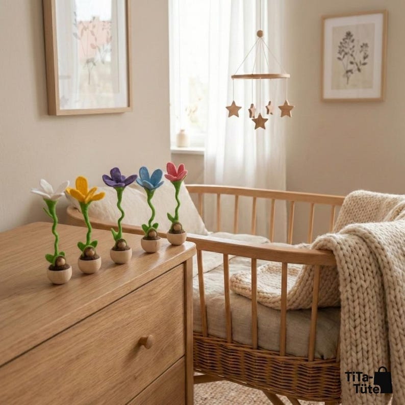 Nachhaltiges Geschenk zur Geburt oder Taufe: Eine Reihe Wurzel-Wichtel steht auf einer Holzkommode im Babyzimmer neben einem Gitterbett. Sanfte und natürliche Kinderzimmer-Deko von TiTa-Tüte