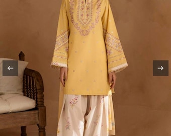 May include: A mustard yellow tunic and matching scarf with intricate embroidery and lace trim. The outfit is paired with wide-leg pants featuring a floral print in shades of pink and yellow. The ensemble is a traditional style.