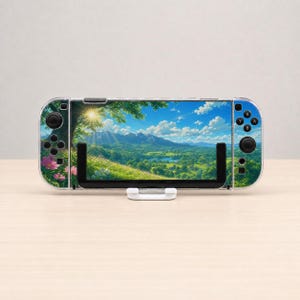 May include: A handheld gaming console featuring a decorative skin with a landscape print of a sunny meadow, green hills, a blue lake, and pink flowers. The device has black control buttons, joysticks, and a directional pad on both sides.