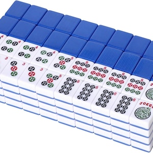 Puede incluir: Un conjunto de fichas de mahjong rectangulares dispuestas en cuadr&iacute;cula, con caras blancas y dorsos azules. Las fichas muestran varios patrones num&eacute;ricos en tinta roja, verde y negra, junto con dos fichas marcadas claramente con la palabra JOKER.
