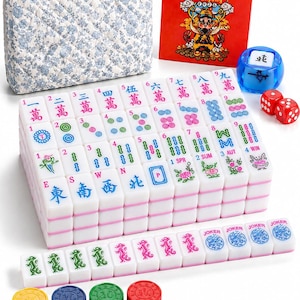 May include: A Mahjong set featuring white tiles with colorful Chinese characters, numbers, and symbols, a blue translucent wind indicator, two red dice, four stacks of colored plastic chips, a floral quilted carrying case, and a red instruction card.