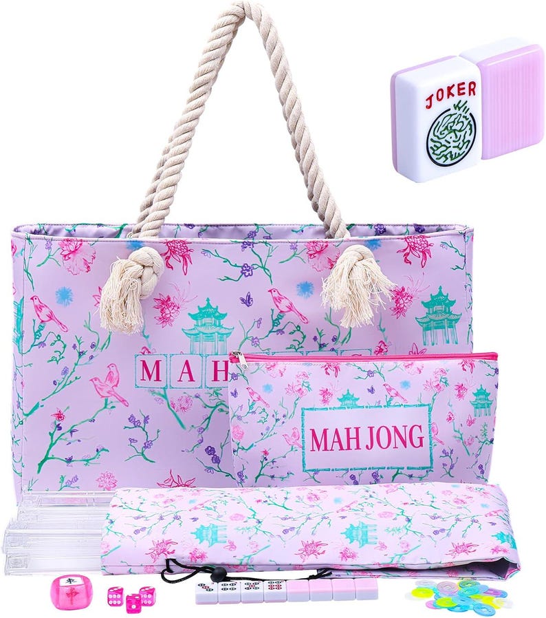 Puede incluir: Un bolso tote de color morado claro con asas de cuerda, con un estampado de p&aacute;jaros, flores y pagodas, y el texto MAH JONG. Incluye un estuche con cremallera a juego, una alfombrilla plegada, una ficha de Joker y varias piezas de juego.