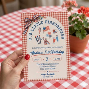 May include: A red and white gingham patterned invitation card with the text "Our Little Firecracker" and "Amelia's 1st Birthday". The card features illustrations of fireworks, ice cream, and the American flag.