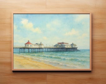 May include: Watercolor painting of a pier extending into the ocean, framed in a light wood. The pier has buildings with red and white roofs. The sky is blue with fluffy clouds, and the beach is golden.