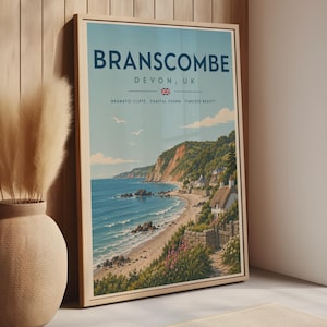 Może przedstawiać: Oprawiony plakat podróżniczy przedstawiający nadmorską scenerię Branscombe w Devon w Wielkiej Brytanii. Nadruk zawiera tekst BRANSCOMBE DEVON, UK, małą flagę Union Jack oraz słowa DRAMATIC CLIFFS COASTAL CHARM TIMELESS BEAUTY nad plażą i klifami.