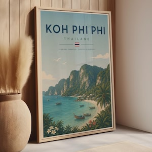 May include: A framed travel poster featuring a coastal landscape of Koh Phi Phi, Thailand. The print displays the text KOH PHI PHI, THAILAND, and TROPICAL PARADISE, ENDLESS DISCOVERY, with a small Thai flag, green cliffs, blue water, and boats.
