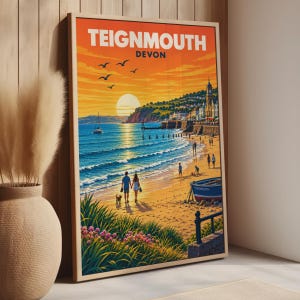 Pode incluir: Um cartaz de viagem emoldurado com uma vista do pôr do sol em Teignmouth, Devon. A ilustração mostra uma praia com um casal a passear um cão, um barco azul e uma torre do relógio. O texto diz TEIGNMOUTH DEVON em letras destacadas.