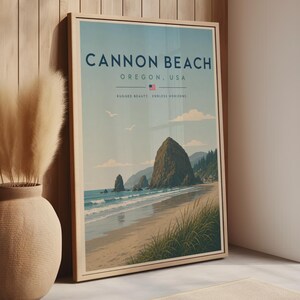 Könnte beinhalten: Ein gerahmtes vertikales Reiseplakat von Cannon Beach, Oregon, USA. Der Druck zeigt eine Küstenlandschaft mit Haystack Rock, Sandstrand, grünem Strandgras und blauen Meereswellen unter einem hellen Himmel. Text: CANNON BEACH, OREGON, USA.