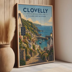 May include: A framed travel poster print of Clovelly, North Devon, England, featuring a cobblestone path leading down to a harbour with boats, stone cottages, and flowers, with the text CLOVELLY NORTH DEVON, ENGLAND A VILLAGE LIKE NO OTHER.