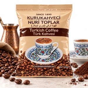 Peut inclure: Un sachet de 100g de café turc Kurukahveci Nuri Toplar. L'emballage beige avec du texte brun présente le nom de la marque, 'Since 1890', et une image d'une tasse et d'une soucoupe à motifs remplies de café, entourées de grains de café torréfiés.