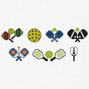 May include: A collection of colorful pickleball-themed illustrations. The designs include pickleball paddles and balls in various arrangements, with colors like red, green, blue, black, and yellow. Some designs include a trophy.