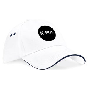 May include: White baseball cap with a curved brim and a black circular patch that reads "K-POP". The cap has a navy blue trim along the brim and two navy blue dots on the side.