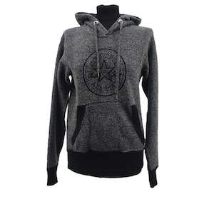 May include: A gray Converse hoodie with a black logo on the front. The hoodie has a drawstring hood, a kangaroo pocket, and black accents on the cuffs and hem. The Converse logo includes a star and the words "CONVERSE ALL STAR".