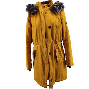 Op de afbeelding: Mosterdgele parka met een met imitatiebont afgezette capuchon. De jas heeft een ritssluiting, knopen en twee voorzakken. De taille is aangesnoerd met een verstelbaar trekkoord. De mouwen hebben zwarte manchetten.