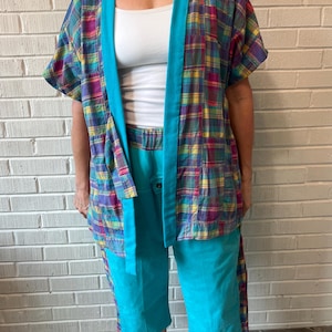 May include: A colorful plaid kimono-style jacket with a turquoise trim and matching capri pants. The jacket features a mix of purple, yellow, and blue squares. The capri pants are a solid turquoise color.