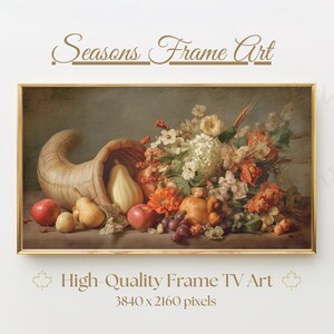 May include: A still life painting featuring a cornucopia overflowing with fruits and flowers. Red apples, pears, and grapes are visible, along with a variety of colorful blooms. The artwork is framed in a gold border, with the text "Seasons Frame Art" at the top.