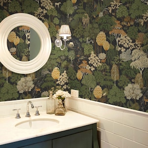 May include: A bathroom vanity with a white marble countertop, a white round mirror, and a wall-mounted light fixture. The wall features dark wallpaper with a dense forest pattern including green and gold trees, white animals, and foliage.