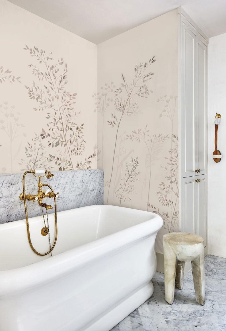 May include: A luxurious bathroom with a white clawfoot tub, marble accents, and a botanical wallpaper design. The brass faucet adds a touch of elegance. A small wooden stool sits nearby, complementing the room's serene aesthetic.