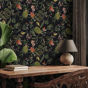 May include: A dark, botanical wallpaper featuring a repeating pattern of green and orange tropical fruits and flowers against a black background. A wooden desk with a lamp and chair are in the foreground.