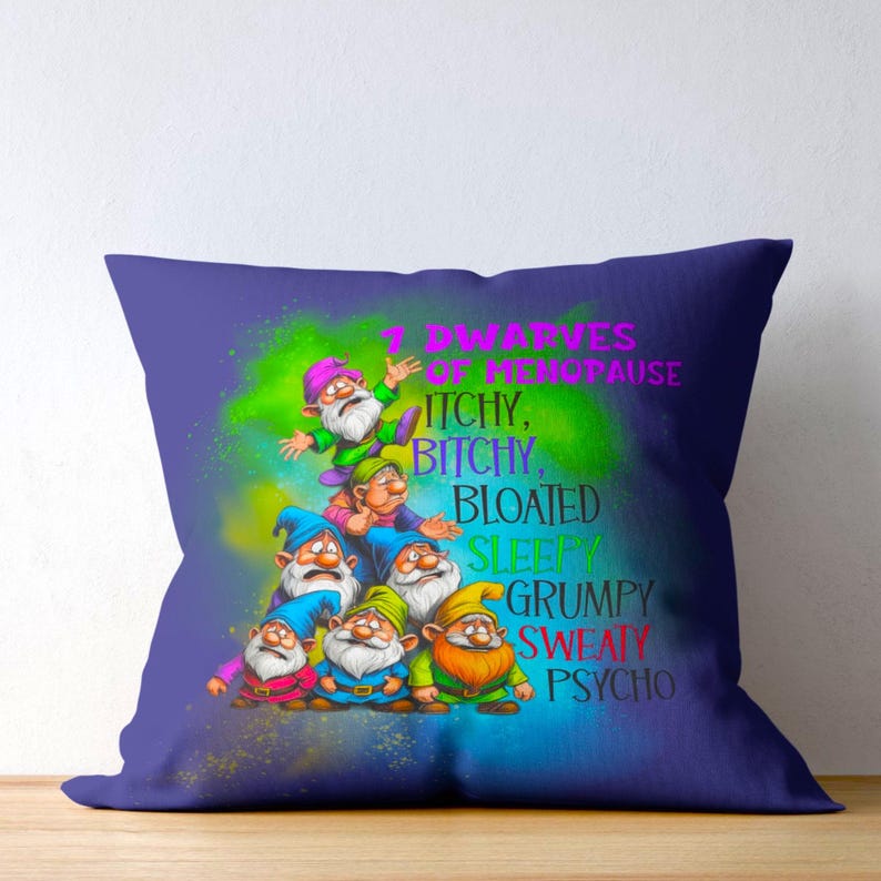May include: A square pillow with a purple background and a design featuring seven cartoon dwarves. The text reads "7 Dwarves of Menopause: Itchy, Bitchy, Bloated, Sleepy, Grumpy, Sweaty, Psycho."