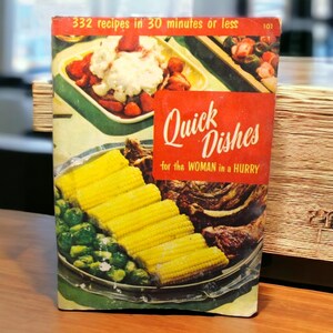 Può includere: Ricettario vintage intitolato "Quick Dishes for the WOMAN in a HURRY" con il testo "332 ricette in 30 minuti o meno". La copertina presenta immagini di cibi preparati, tra cui pannocchie di mais, cavoletti di Bruxelles e fragole.