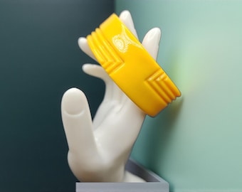 Brazalete vintage de acrílico amarillo estilo Art Déco de los años 80 con diseño geométrico de chevron y plástico.