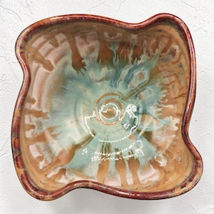 May include: A white ceramic mug with a black handle and the text "But First, Coffee" in a bold, black font. The mug is set against a neutral background, highlighting its simple design.