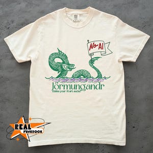 May include: Cream-colored t-shirt featuring a green illustration of a sea serpent with the text "Jörmungandr" and a banner that reads "No AI". The shirt also includes the text "thinks your AI art sucks".