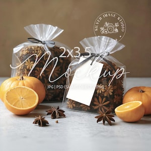 Puede incluir: Dos bolsas transparentes de celofán atadas con cintas grises, llenas de anís estrellado. Las bolsas están junto a calabazas naranjas y naranjas en rodajas. La imagen tiene el texto "Mockup" y "2x3.5".
