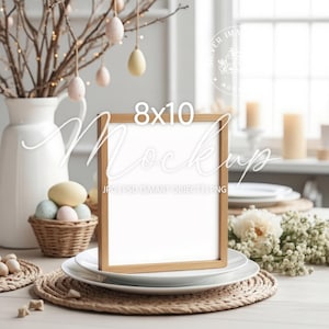 May include: An 8x10 inch wooden frame mockup, displayed on a white plate atop a woven placemat. The scene includes Easter eggs, a white vase with branches, and decorative elements, creating a spring-themed setting.