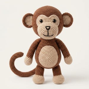 May include: A crocheted monkey toy featuring dark brown yarn for the head, body, arms, and tail, with light beige yarn on the face, ears, belly, hands, and feet. The monkey has black plastic eyes and a stitched black nose and mouth.