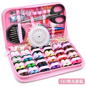 May include: A pink zippered sewing kit containing various sewing supplies. The kit includes scissors, needles, spools of thread, pins, and a measuring tape. The text "30 ASSORTED NEEDLES" is visible. The kit is labeled "147 pieces set".