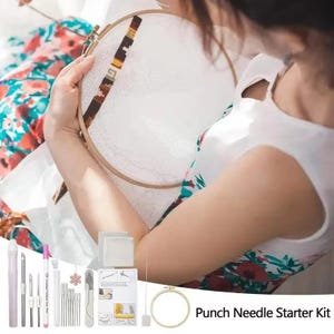Puede incluir: Un kit de inicio de aguja mágica con varias herramientas, incluyendo agujas, un bastidor de bordado de madera y una guía. La imagen muestra a una persona trabajando en un proyecto de punto de cruz. El texto "Punch Needle Starter Kit" es visible.