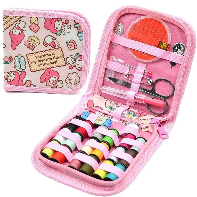 May include: A pink sewing kit with a zippered case and a matching small pouch. The kit contains spools of thread, needles, scissors, and other sewing notions. The pouch has a pattern with cartoon characters and the text "Tea time is my favorite time of the day!"