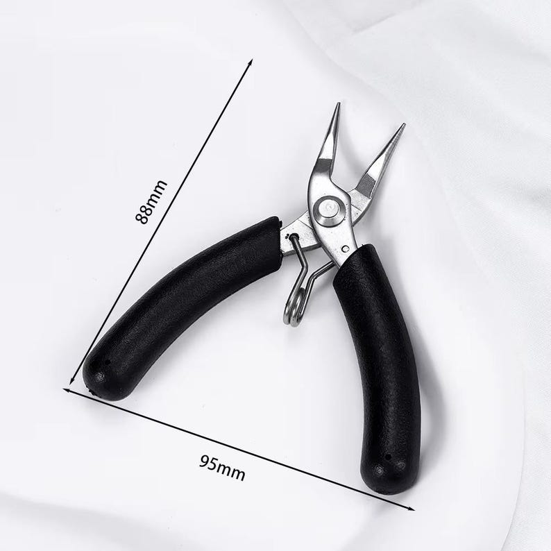 May include: Needle-nose pliers with black handles, measuring 3.5 inches long and 3.5 inches wide. The pliers are made of silver metal and are designed for precision work. The image shows the pliers open, with the tips pointing upwards.