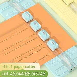 Puede incluir: Un cortador de papel con una base azul claro y una guía de corte transparente. El papel naranja está siendo cortado por cuatro deslizadores blancos y azul claro. El texto de la imagen dice "4 in 1 paper cutter" y "cut A3/A4/B5/A5/A6".