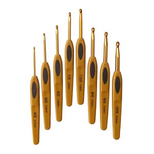 Peut inclure: Un ensemble de huit crochets avec des pointes en métal doré et des manches beiges avec des poignées ovales noires. Les tailles indiquées vont de 4/0 (2,5 mm) à 10/0 (6,0 mm).