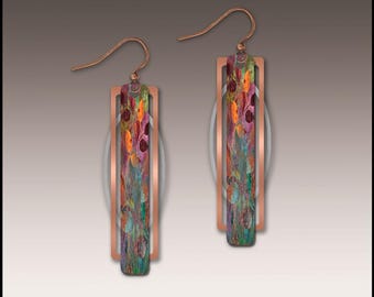 May include: A pair of dangle earrings featuring a rectangular copper-toned frame surrounding a central vertical bar with a multi-colored abstract pattern of orange, purple, and teal hues. The earrings are suspended from curved copper-toned ear wires.