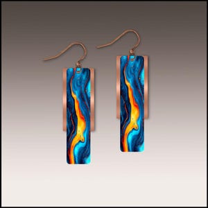 May include: A pair of copper-colored dangle earrings. Each earring features a rectangular, copper-colored frame with a vibrant, abstract design in shades of blue, orange, and yellow. The earrings have a hook closure.