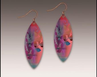 Könnte beinhalten: Ein Paar ohrförmige Ohrringe mit farbenfrohem Design. Die Ohrringe weisen einen Farbverlauf aus Rosa, Lila und Blau mit einem floralen Muster auf. Die Ohrhaken sind kupferfarben.