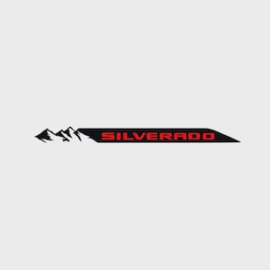 Peut inclure: Logo Silverado noir et rouge avec un motif de chaîne de montagnes. Le mot "SILVERADO" est en rouge, et les montagnes sont en noir et blanc. Le logo est rectangulaire avec une extrémité pointue.