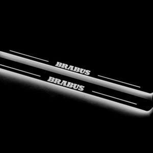 Może przedstawiać: Czarne progi drzwi samochodu z nazwą marki "BRABUS" w kolorze białym, podświetlane miękkim, białym światłem. Progi mają elegancki, nowoczesny design, idealny dla entuzjastów motoryzacji.