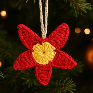 May include: A handmade, red and yellow crocheted flower ornament with a beige string for hanging. The five-petal flower has a bright yellow center and is set against a blurred background of a Christmas tree.