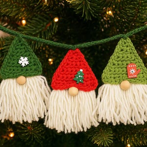 May include: A festive Christmas garland featuring three crocheted gnome ornaments. Each gnome has a green or red pointed hat, a wooden nose, and a long white beard. The hats are adorned with snowflake, tree, and mitten embellishments.