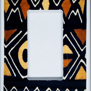 May include: A white light switch cover with a black, brown and white geometric pattern.