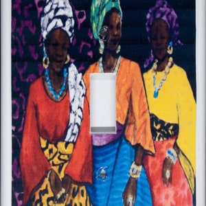May include: Three women wearing colorful head wraps and traditional clothing stand together. The woman on the left wears a red top with a yellow and black patterned skirt. The woman in the middle wears a blue and orange top with a blue skirt. The woman on the right wears a yellow top with a red skirt. The women are all smiling.