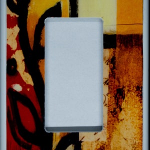 May include: A light switch cover with an abstract design featuring red, yellow, orange, and black colours. The design includes a black vine-like pattern and a yellow and orange geometric shape.