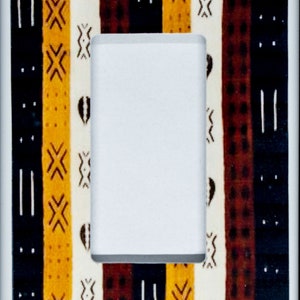 May include: A white light switch cover featuring a decorative design of black, brown and yellow stripes with geometric patterns.